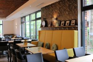 a restaurant with tables and chairs and windows at Plauderei Café und Hotel in Bad Zwischenahn