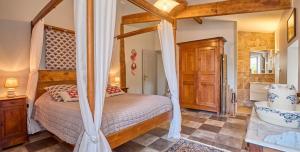 a bedroom with a canopy bed and a tub at Chez Moutier in Monestier +38 photos
