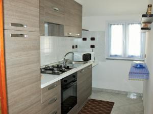 a kitchen with a sink and a stove top oven at Casa Vacanze Nuraghe Talia in Olmedo