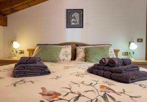 a bedroom with a bed with towels on it at Casa Flora -lakefront and Tre Cime view in Auronzo di Cadore