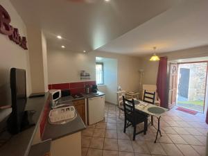 a kitchen and living room with a table and chairs at Apartment in Mostuejouls in Mostuéjouls