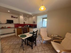 a kitchen and living room with a table and chairs at Apartment in Mostuejouls in Mostuéjouls +7 photos
