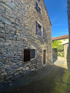 a stone building with a door and a window at Apartment in Mostuejouls in Mostuéjouls