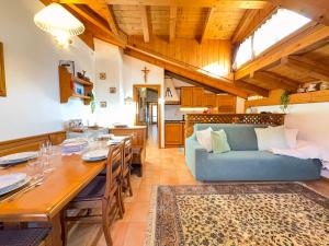 a living room with a table and a blue couch at Casa Flora -lakefront and Tre Cime view in Auronzo di Cadore