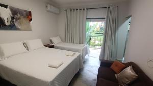 a hotel room with two beds and a chair at Pousada Real in Caldas Novas +85 photos