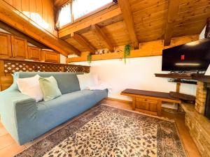 a living room with a blue couch and a table at Casa Flora -lakefront and Tre Cime view in Auronzo di Cadore