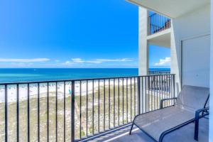 a chair on a balcony with a view of the beach at Phoenix 6 Unit 1209 in Orange Beach +53 photos