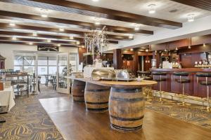 a bar in a restaurant with wooden floors and tables at Hotel Pinenhus in Glyngøre