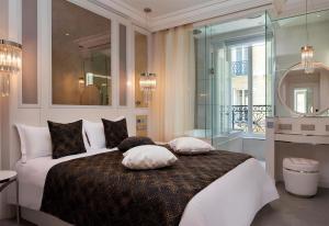 a bedroom with a large bed with pillows on it at Paris j'Adore Hotel & Spa in Paris