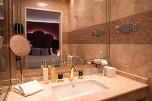 a bathroom with a sink and a large mirror at Paris j'Adore Hotel & Spa in Paris
