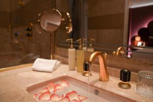 a bathroom with a sink with pink hearts in it at Paris j'Adore Hotel & Spa in Paris