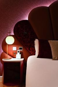 a bedroom with a bed and a table with a lamp at Paris j'Adore Hotel & Spa in Paris +131 photos