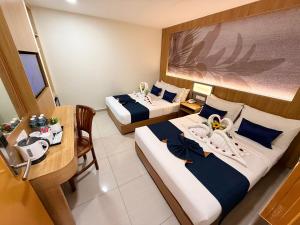 a hotel room with two beds and a table at City Central Hotel in Kuala Lumpur