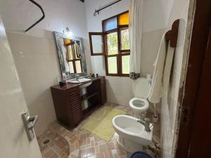a bathroom with a toilet and a sink and a mirror at Nyumba Malaika in Malindi