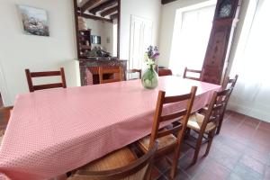 a dining room with a pink table and chairs at Villa le Roche du Ris - 10-12 personnes in Baraize