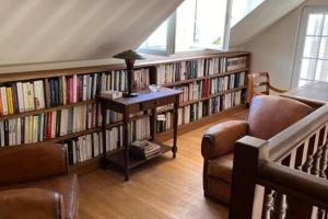 a library with book shelves filled with books at Villa le Roche du Ris - 10-12 personnes in Baraize