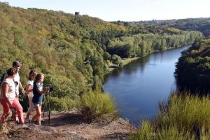 a group of people standing on a hill overlooking a river at Villa le Roche du Ris - 10-12 personnes in Baraize