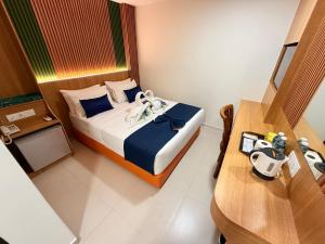 a small bedroom with a bed and a table at City Central Hotel in Kuala Lumpur