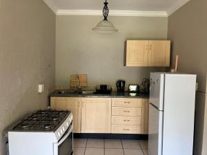 a kitchen with a stove and a white refrigerator at Cave view Cottages in Muldersdrift