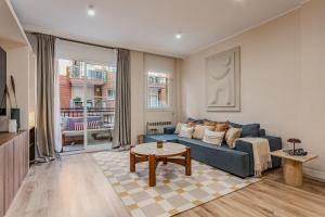 a living room with a blue couch and a table at Comfortable and spacious flat in Barcelona in Barcelona