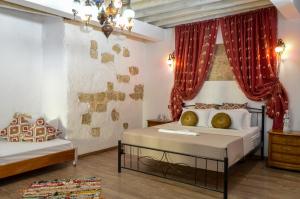 a bedroom with two beds with red curtains at Fatma Hanoum Old Town in Rhodes Town