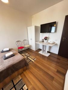 a bedroom with a bed and a desk with a television at Studio M in Timişoara