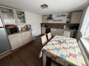 a kitchen with a table with a quilt on it at Ferienwohnung Lippmann in Großhartmannsdorf