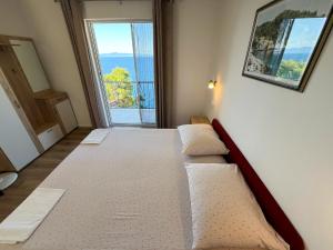 a bedroom with a bed and a large window at Robinson Olympos in Gdinj