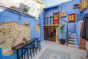 a blue building with a table and stools at Fatma Hanoum Old Town in Rhodes Town