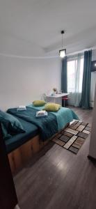a bedroom with a large bed with a green blanket at Studio M in Timişoara