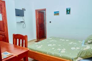 a small bedroom with a bed and a table at Chez Sabine in Abomey