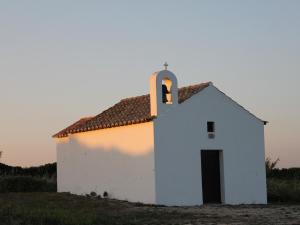 a small white chapel in a field at Monte de Santo Antonio - Turismo Rural in Vila do Bispo +19 photos