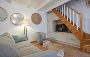 a living room with a couch and a staircase at Maison Proche Port Et Plage in Saint-Vaast-la-Hougue