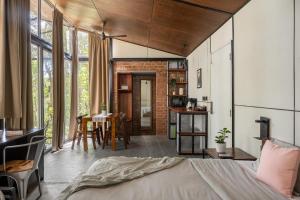 a bedroom with a bed and a dining room with a table at Cove by Raho - Nestled Away Retreat in Siddapur