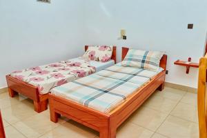 two twin beds in a room with at Chez Sabine in Abomey