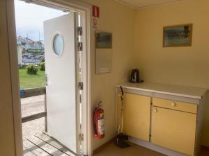 a kitchen with a counter and a door leading to a yard at Badholmens Vandrarhem in Fjällbacka +18 photos