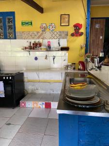 a kitchen with a counter with plates on it at Pousada e Hostel Cantinho dos Chalés in São Luiz do Paraitinga