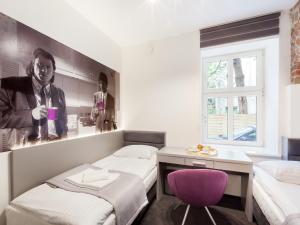 ポズナンにあるCinema Hostelのベッド2台と紫色の椅子が備わる客室です。