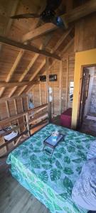 a large bed in a room with a wooden ceiling at Cabana Rústica Praia do Sonho in Palhoça