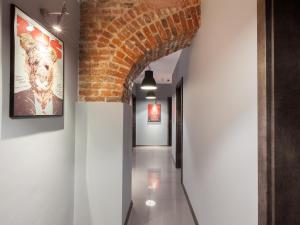a hallway with a brick wall and an archway at Cinema Hostel in Poznań