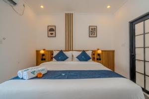 a bedroom with a large white bed with blue pillows at Little Soho Pererenan in Canggu