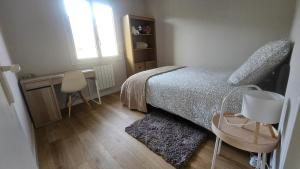 a bedroom with a bed and a desk and a window at Villa Berninoise in Bernin