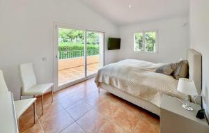 a white bedroom with a bed and a balcony at Villa Rondo in Costa de la Calma