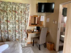 a room with a desk with a chair and a mirror at SETLHARE GUEST LODGE in Ganyesa