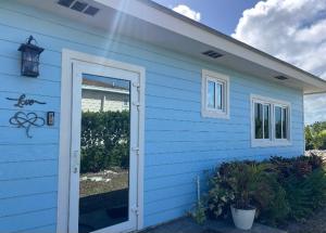 a blue house with a door in front of it at Vacation Haven Cottages in Rolleville