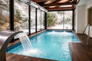 a swimming pool with a waterfall in a house at Hotel Riberies & Spa by RdA Hotels in Llavorsí