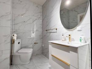 a white bathroom with a toilet and a mirror at YANG 23rd Floor Panoramic View & King Bed, Parkin in Cluj-Napoca +21 photos