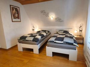 two twin beds in a room with two lamps at Hillis Ferienwohnung Saarland in Sankt Ingbert