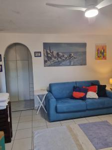 a blue couch in a living room with a painting at Casa ARLECCHINA in Rio Marina