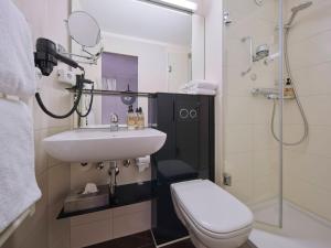 a bathroom with a sink and a toilet and a shower at Classik Hotel Martinshof, Messe München in Munich